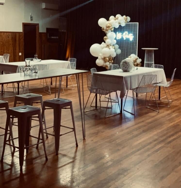 Decorated tables with white cloths and party settings inside the hall